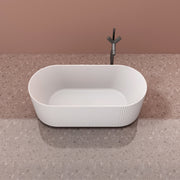 Modern fluted solid surface soaking tub with center drain