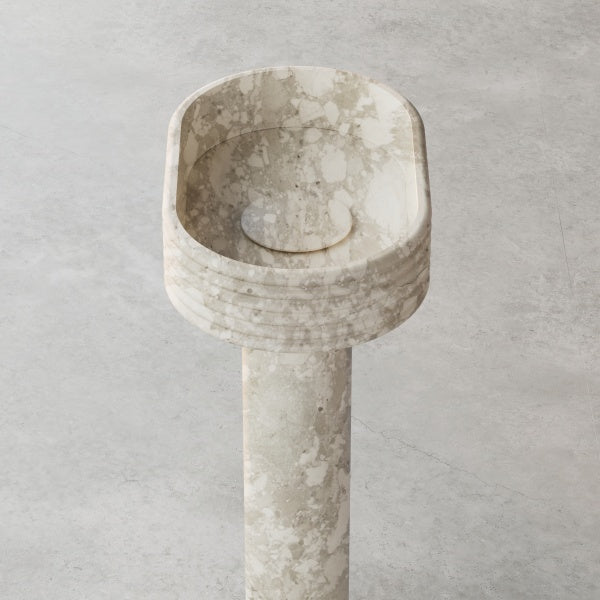 STRATA sculptural pedestal sink with linear marble detailing